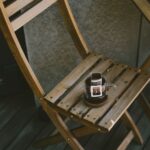 Holzstuhl mit Filterkaffeemaschine auf einer Terrasse, der eine friedliche Morgenstimmung schafft.