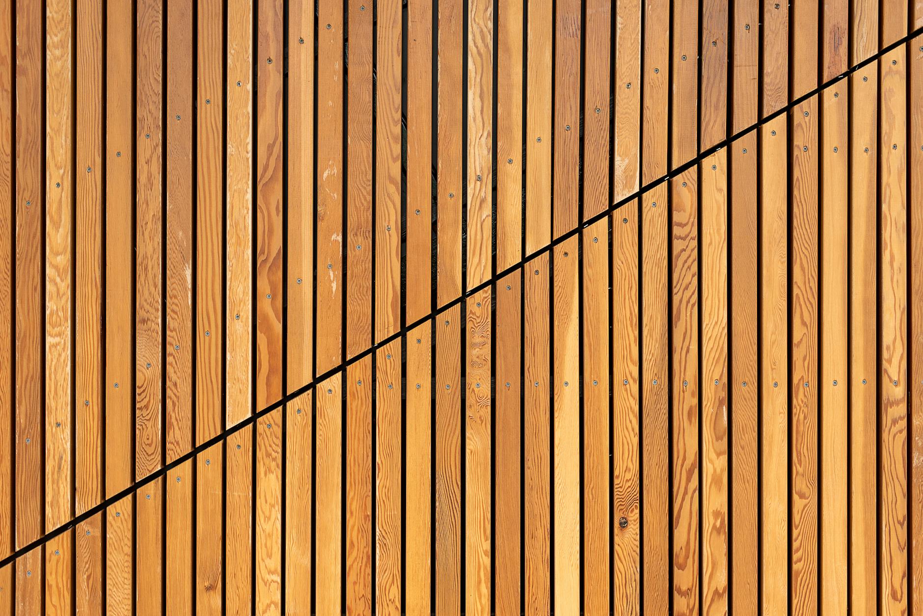 Eine Nahaufnahme von Holzlatten, die ein modernes diagonales Muster bilden, ideal für Hintergründe.